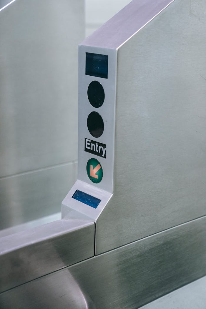 about-img-02 Close-up of a metro station entry gate with scanner and directional arrow.